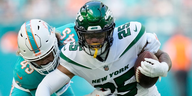 Miami Dolphins linebacker Duke Riley (45) tackles New York Jets running back Ty Johnson (25) during the first half of an NFL football game, Sunday, Jan. 8, 2023, in Miami Gardens, Florida.