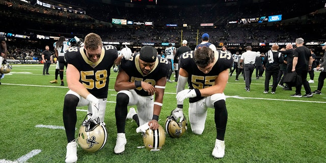 New Orleans Saints linebacker Ty Summers, left to right, linebacker Andrew Dowell and linebacker Kaden Elliss say a prayer on the field for Buffalo Bills player Damar Hamlin after a 2019 football game. the NFL between the Carolina Panthers and the New Orleans Saints in New Orleans on Sunday, January 1.  8, 2023. 