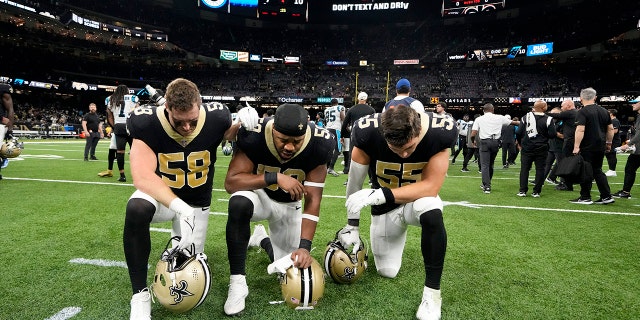 El apoyador de los New Orleans Saints, Ty Summers, desde la izquierda, el apoyador Andrew Dowell y el apoyador Kaden Elliss dicen una oración en el campo por la jugadora de cuadro de los Buffalo Bills, Damar Hamlin, después de un partido de fútbol americano de la NFL entre Carolina Panthers Caroline y los New Orleans Saints en Nueva Orleans, el domingo de enero. 8. 2023. 