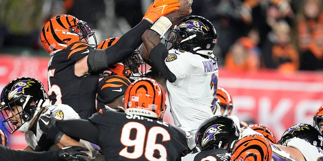 Baltimore Ravens quarterback Tyler Huntley (2) loses the ball when Cincinnati Bengals linebacker Logan Wilson, left, tackles him in the second half of a wild card playoff football game in the NFL in Cincinnati, Sunday, January 15, 2023. Bengals' Sam Hubbard recovered the fumble and ran back for a touchdown.