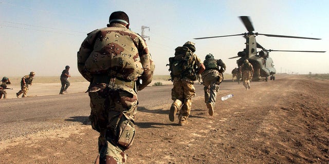 BESTAND: Soldaten van het Britse leger, van het Royal Welch Fusiliers Regiment en de Iraqi National Guard, stappen weer aan boord van een Chinook-helikopter in Zuid-Irak, tijdens de eerste gezamenlijke Eagle-inspectiepatrouille in de lucht. 