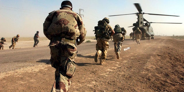 BESTAND: Soldaten van het Britse leger, van het Royal Welch Fusiliers Regiment en de Iraqi National Guard, stappen weer aan boord van een Chinook-helikopter in Zuid-Irak, tijdens de eerste gezamenlijke Eagle-inspectiepatrouille in de lucht. 