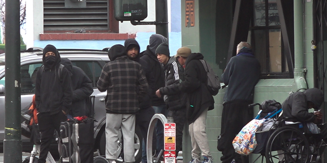 Drug dealers and drug users huddle together across the street from the San Francisco Federal Building. 