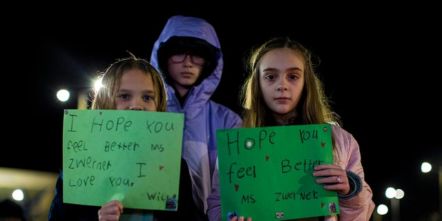 Willow Crawford, left, and her older sister Ava, right, join friend Kaylynn Vestre, center, in expressing their support for Richneck Elementary School first-grade teacher Abby Zwerner during a candlelight vigil in her honor at the School Administration Building in Newport News, Va., Monday, Jan. 9, 2023. 