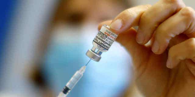 A medical worker prepares a dose of the Pfizer-Bivalent coronavirus vaccine at a vaccination center in Nice, France, on Dec. 7, 2022. The EU is working on paying more in exchange for a lower volume of Pfizer vaccines after agreeing to buy half a billion doses earlier in the year.