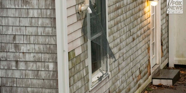 A screen is torn out from the back window of the home at 516 Chief Justice Cushing Hwy in Cohasset, Mass., Friday, Jan. 6, 2023. The home belongs to Ana Walshe, who has been reported missing. She was last seen New Year's Day.