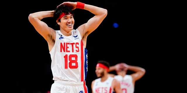 Japonya'nın Brooklyn Nets takımından Yuta Watanabe (18), 2 Ocak 2023 Pazartesi, New York'ta San Antonio Spurs'a karşı bir NBA basketbol maçının ilk yarısında Kyrie Irving'in smaç yapmasını takım arkadaşlarıyla kutluyor. 