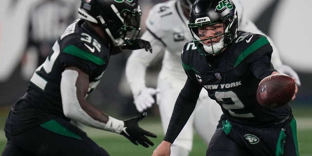 El mariscal de campo de los New York Jets, Zach Wilson, entrega el balón al corredor Michael Carter contra los Jacksonville Jaguars, el 22 de diciembre de 2022, en East Rutherford, Nueva Jersey.