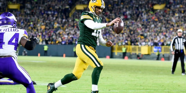 Aaron Rodgers #12 of the Green Bay Packers runs for a two-yard touchdown run during the fourth quarter for the Minnesota Vikings at Lambeau Field on January 1, 2023 in Green Bay, Wisconsin.