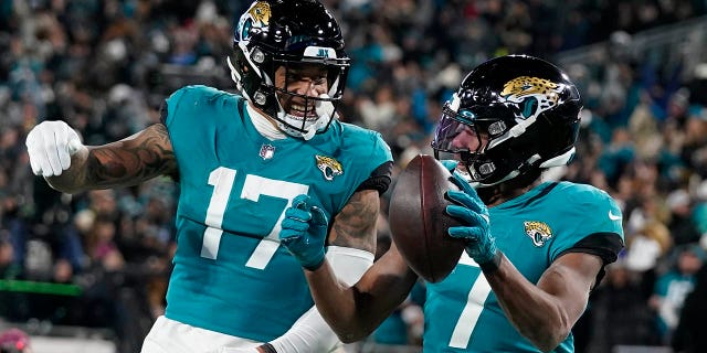 Le receveur large des Jaguars de Jacksonville Zay Jones (7) célèbre son touché avec l'ailier serré Evan Engram (17) lors du deuxième match de football de la NFL contre les Chargers de Los Angeles, le samedi 14 janvier 2023, à Jacksonville, en Florida. 