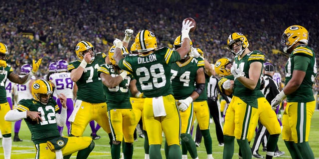 AJ Dillon #28 de los Green Bay Packers celebra con sus compañeros de equipo después de correr por un touchdown contra los Minnesota Vikings durante el último cuarto del juego en Lambeau Field el 1 de enero de 2023 en Green Bay, Wisconsin.