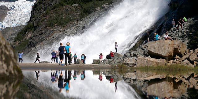 Tourists visit Mendenhall Glacier in the Tongass National Forest as they head to Nugget Falls in Juneau, Alaska on July 31, 2013.