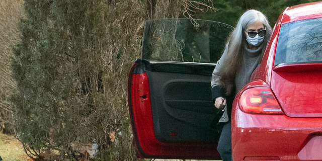 A woman who appears to be Diana Walshe is shown outside a red VW Bug.