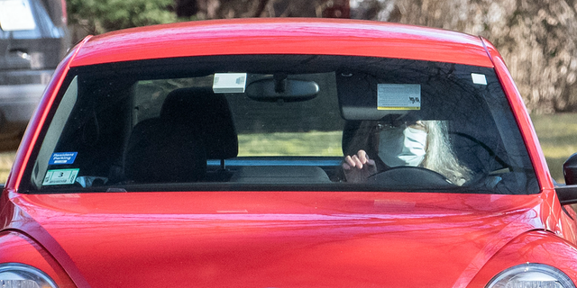 Een vrouw die Diana Walshe lijkt te zijn, rijdt in een rode VW Bug-auto.