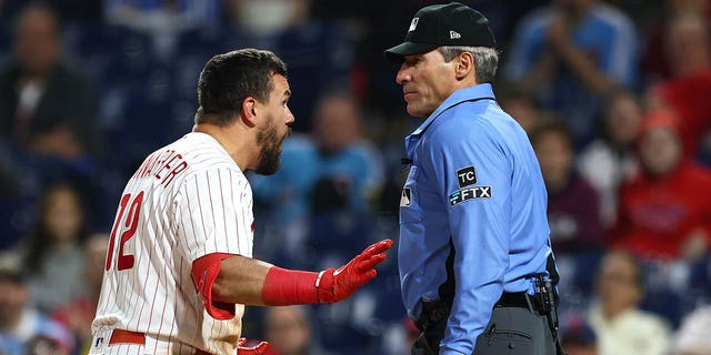 Kyle Schwarber #12 of the Philadelphia Phillies argues with plate umpire Angel Hernandez after being called for strikes during the ninth inning against the Milwaukee Brewers at Citizens Bank Park on April 24, 2022 in Philadelphia, Pennsylvania.  The Brewers defeated the Phillies 1-0.