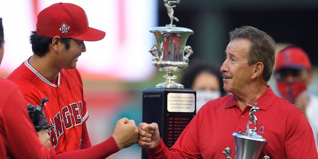 Shohei Ohtani #17 of the Los Angeles Angels gets a bump from Arte Moreno before being given the Angels Most Valuable player award before playing the Seattle Mariners at Angel Stadium of Anaheim on September 25, 2021 in Anaheim, California.