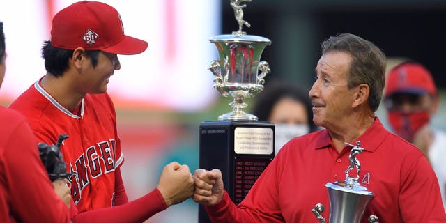 Shohei Ohtani #17 of the Los Angeles Angels gets a bump from Arte Moreno before being given the Angels Most Valuable player award before playing the Seattle Mariners at Angel Stadium of Anaheim on September 25, 2021 in Anaheim, California.