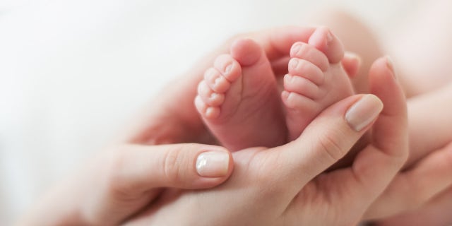 baby feet in mother's hands