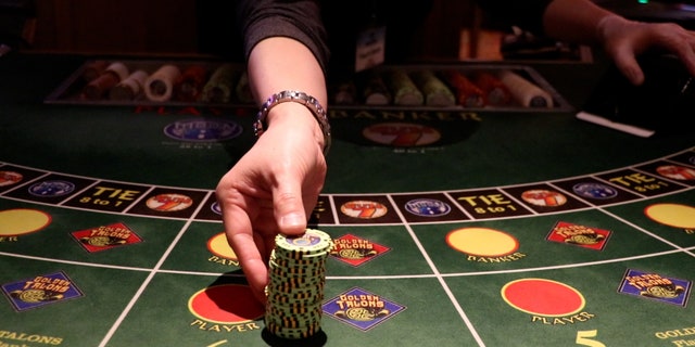 An employee distributes chips at a baccarat table at Great American Casino in Tukwila, Washington.