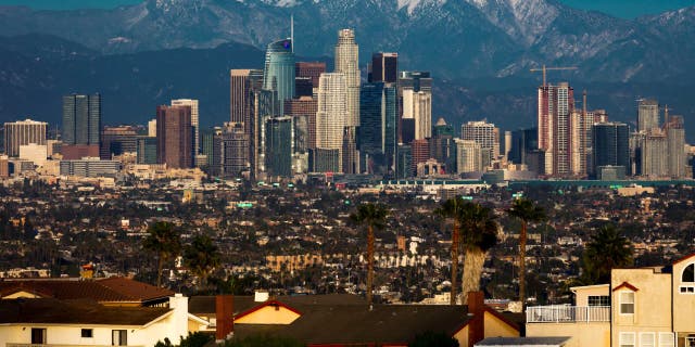 Los Angeles skyline framed by San Bernadino Mountains and Mount Baldy with fresh snow from Kenneth Hahn State Park.