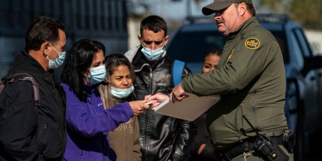 Migrants wait for their turn to have a Border Patrol agent write down their information in Eagle Pass, Texas on December 20, 2022.