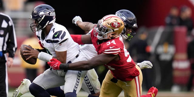 Seattle Seahawks quarterback Geno Smith (7) is pressured by San Francisco 49ers defensive end Charles Omenihu (94) during the second half of a wild-card playoff football game in Santa Clara, Calif., Jan. 14, 2023.