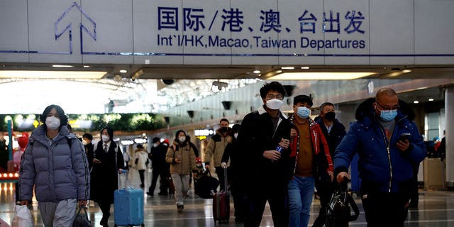Travelers walk at the Beijing Capital International Airport on Dec. 27, 2022, amid a COVID-19 outbreak in China. 