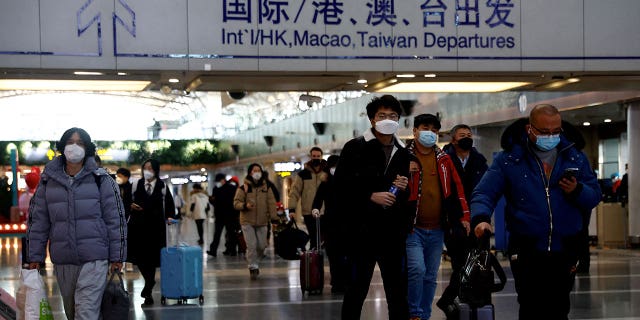 Travelers walk at the Beijing Capital International Airport on Dec. 27, 2022, amid a COVID-19 outbreak in China. 