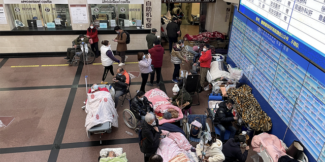 Patienten liegen auf Betten und Tragen in einem Korridor einer Notaufnahme eines Krankenhauses inmitten des Coronavirus-Ausbruchs in Shanghai, China, 4. Januar 2023. 
