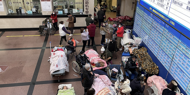 I pazienti giacciono su letti e barelle in un corridoio di un pronto soccorso ospedaliero, durante l'epidemia di coronavirus a Shanghai, Cina, 4 gennaio 2023. 