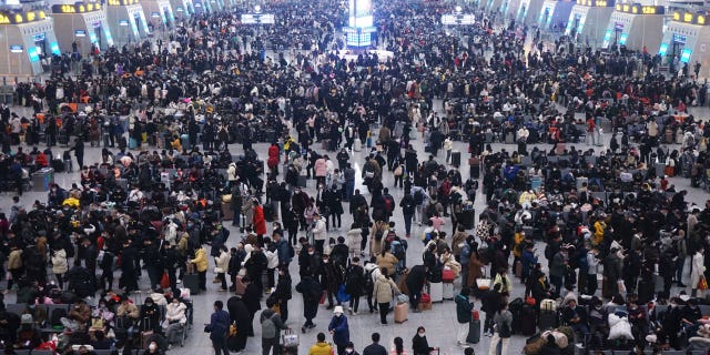 Travelers in China are beginning to crowd transit stations as Lunar New Year festivities begin, with government officials downplaying COVID transmission risks and reporting declining numbers.