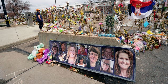 Tributes cover the temporary fence around the King Soopers grocery store in which 10 people died in a mass shooting in Boulder, Colorado.