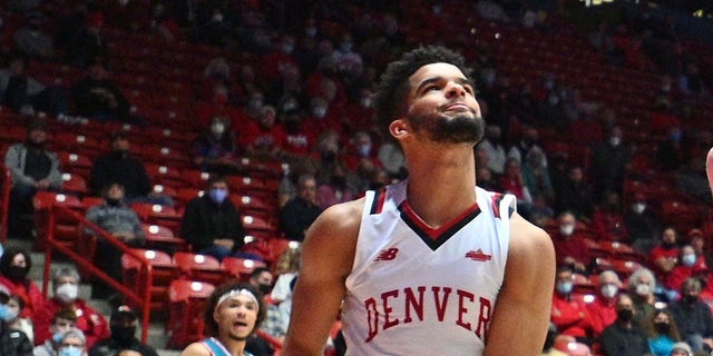 Sebastian Forsling #3 of the New Mexico Lobos dunks during their game against Coban Porter #5, Taylor Gatlin #4 and KJ Hunt #2 of the Denver Pioneers on December 9, 2021 in Albuquerque, New Mexico.