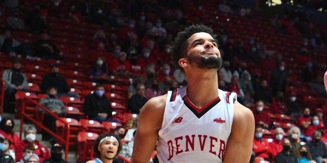 Sebastian Forsling #3 de los New Mexico Lobos clava a Coban Porter #5, Taelyr Gatlin #4 y KJ Hunt #2 de los Denver Pioneers durante su juego en The Pit el 9 de diciembre de 2021 en Albuquerque, Nuevo México.