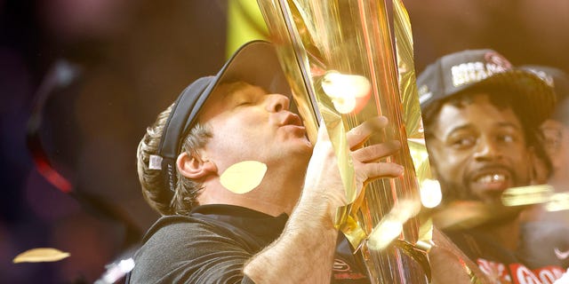 Georgia Bulldogs head coach Kirby Smart kisses the National Championship trophy after defeating the TCU Horned Frogs in the College Football National Championship game at SoFi Stadium on January 9, 2023 in Inglewood, California.  Georgia defeated TCU 65-7.