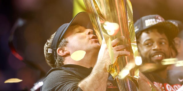 Georgia Bulldogs head coach Kirby Smart kisses the National Championship trophy after defeating the TCU Horned Frogs in the College Football National Championship game at SoFi Stadium on January 9, 2023 in Inglewood, California.  Georgia defeated TCU 65-7.