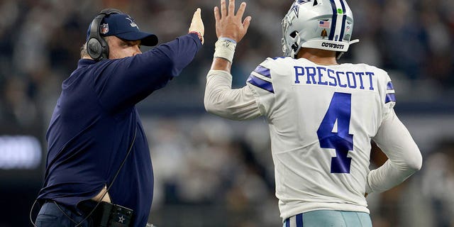Dallas Cowboys head coach Mike McCarthy celebrates with quarterback Dak Prescott, #4, after the Cowboys scored a touchdown against the Houston Texans in the fourth quarter at AT&T Stadium on December 11, 2022 in Arlington , Texas.