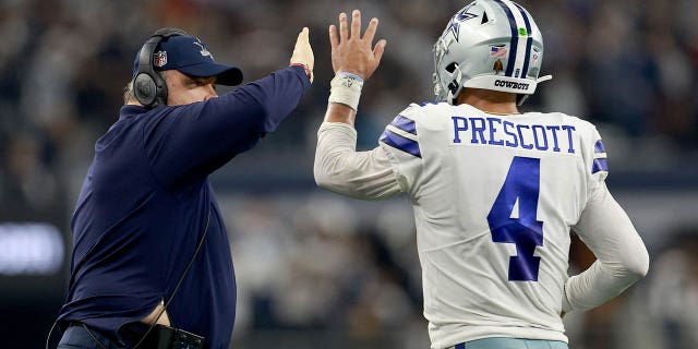 Hoofdcoach Mike McCarthy van de Dallas Cowboys viert feest met quarterback Dak Prescott, #4, nadat de Cowboys een touchdown scoorden tegen de Houston Texans in het vierde kwartaal in het AT&T Stadium op 11 december 2022 in Arlington, Texas.