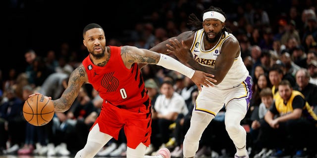 Damian Lillard #0 of the Portland Trail Blazers dribbles against Patrick Beverley #21 of the Los Angeles Lakers during the fourth quarter at the Moda Center on January 22, 2023 in Portland, Oregon.