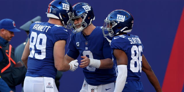 Daniel Jones dari New York Giants diberi selamat oleh rekan setimnya setelah mencetak touchdown melawan Indianapolis Colts pada 1 Januari 2023, di East Rutherford, New Jersey.