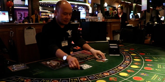 An employee deals cards at Maverick Gaming's Great American Casino in Tukwila, Washington. Card rooms in the state are permitted to have up to 15 tables where customers can play games such as poker and blackjack.