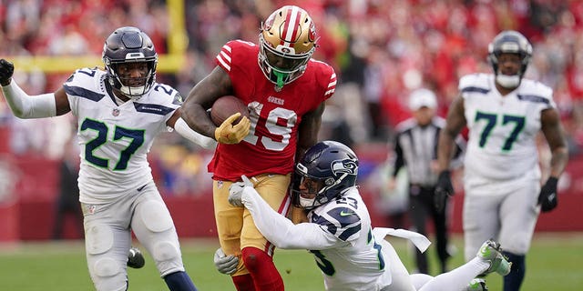 San Francisco 49ers wide receiver Deebo Samuel (19) is defended by Seattle Seahawks safety Johnathan Abram (23) and cornerback Tariq Woolen (27) in the third quarter of a wild-card game at Levi's Stadium.