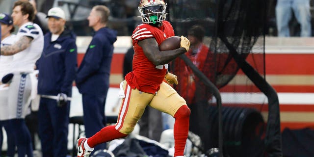 El receptor abierto de los San Francisco 49ers, Deebo Samuel (19), corre hacia la zona de anotación para anotar durante la segunda mitad de un juego de comodines de la NFL contra los Seattle Seahawks en Santa Clara, California, el sábado 14 de enero de 2023. 