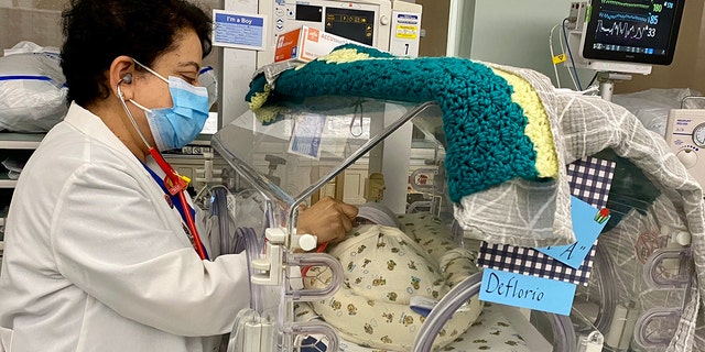 Dr. Devarajan is shown in the NICU with one of the babies born on Dec. 29.