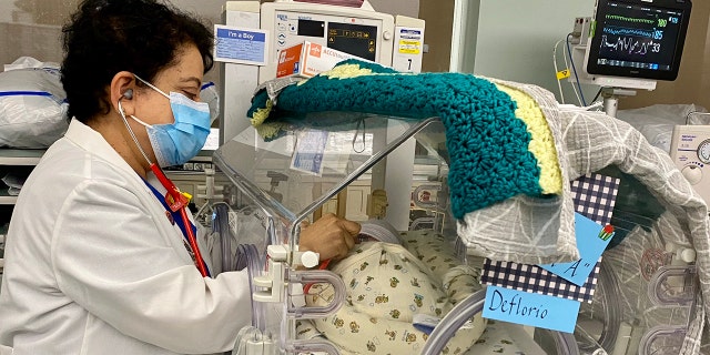 Dr. Devarajan is shown in the NICU with one of the babies born on Dec. 29.
