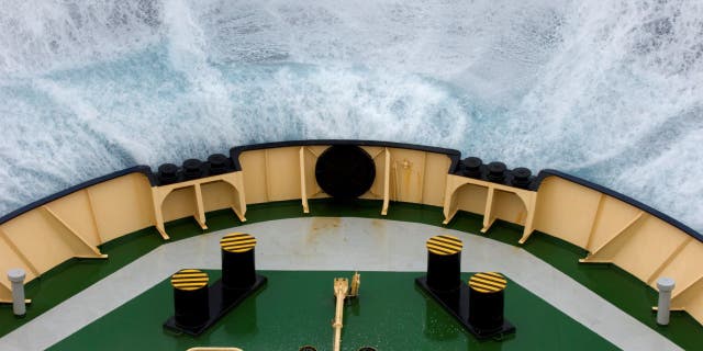 The bow of the icebreaker Kapitan Khlebnikov pushes through a wave while crossing the Drake Passage in rough seas.