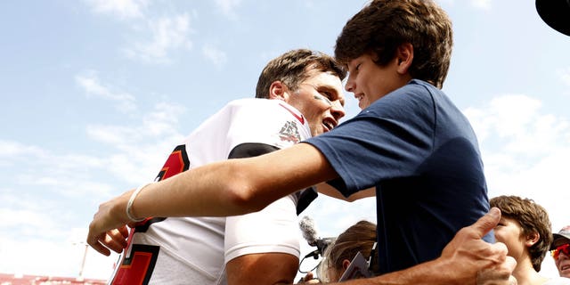 Tampa Bay Buccaneers' Tom Brady hugs his son John Edward Thomas Moynahan on the sideline before a game against the Green Bay Packers at Raymond James Stadium.