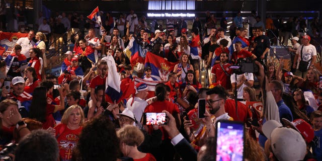 Fans of Serbia's Novak Djokovic celebrate his victory against Russia's Andrey Rublev in their men's singles quarter-final match on day ten of the Australian Open tennis tournament in Melbourne on January 25, 2023.