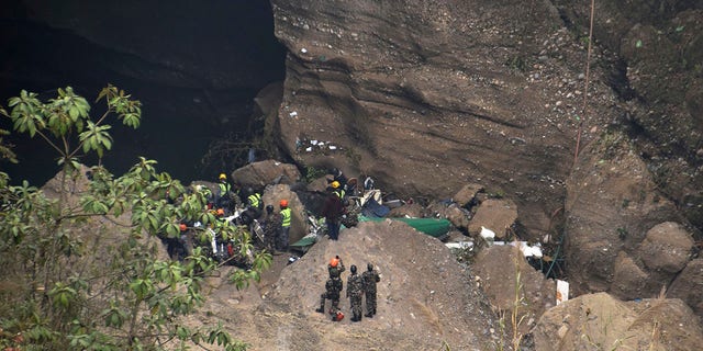 Nepalese rescue workers inspect wreckage at the site of a plane crash in Pokhara, Nepal, Monday, Jan. 16, 2023. 