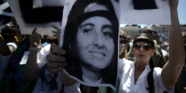 A demonstrator holds a poster of Emanuela Orlandi reading "Missing" during Pope Benedict XVI's Regina Coeli noon prayer in St. Peter's square, at the Vatican on May 27, 2012. Fifteen-year-old Emanuela Orlandi, the daughter of a Vatican messenger who lived with his family in Vatican City, disappeared in 1983.